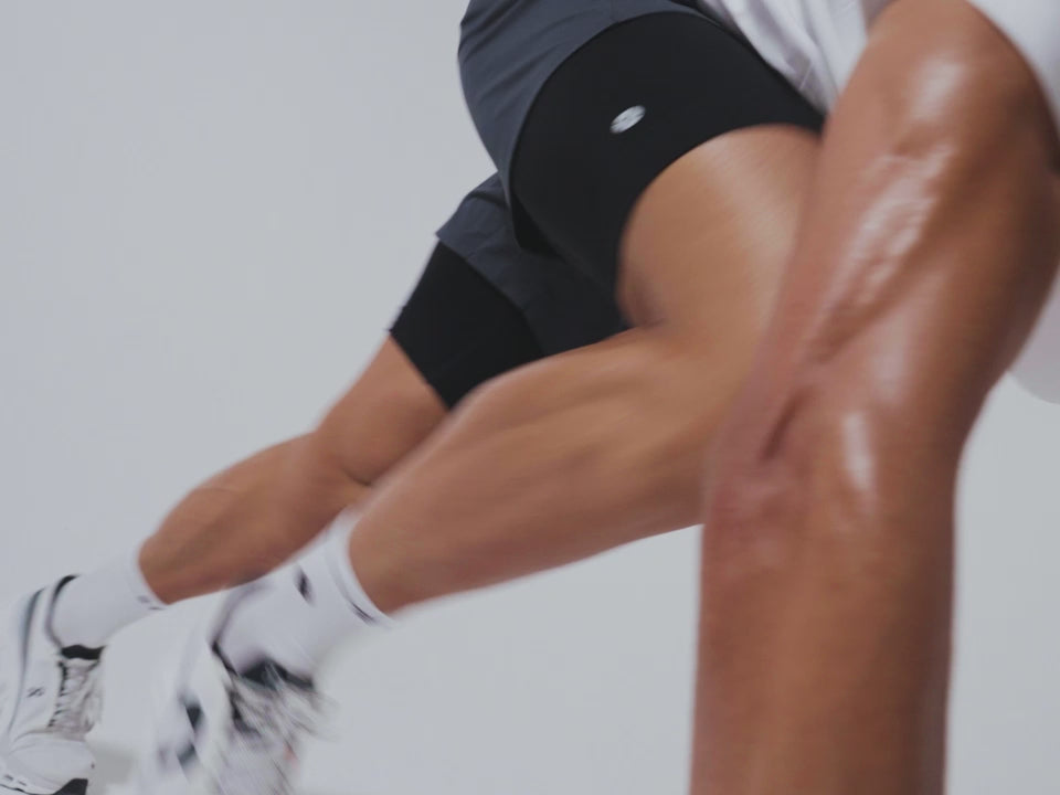 A man in motion, moving his feet towards his arms.